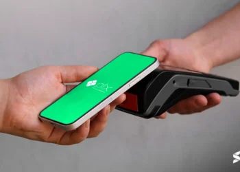Pessoa fazendo pagamento por aproximação com o celular usando PIX em um terminal de pagamento.