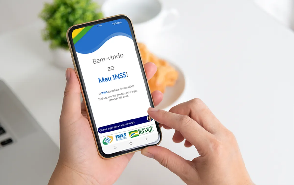 Pessoa acessando o aplicativo Meu INSS no celular.