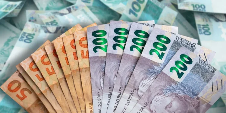 Notas de 50 e 200 reais seguradas por uma mão, com cédulas de 100 reais desfocadas ao fundo.